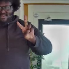 Human makes a 'scissors' hand gesture palm-forward